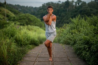 Erkek, dışarıda yoga ve meditasyon pratiği yapıyor.