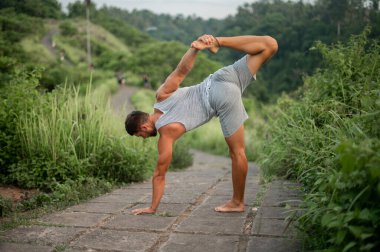 Erkek, dışarıda yoga ve meditasyon pratiği yapıyor.