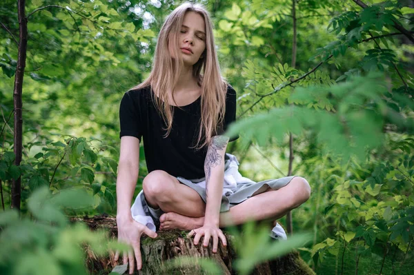 A meditáció gyakorlata és a természettel való kölcsönhatás. Lány a zöld erdőben — Stock Fotó