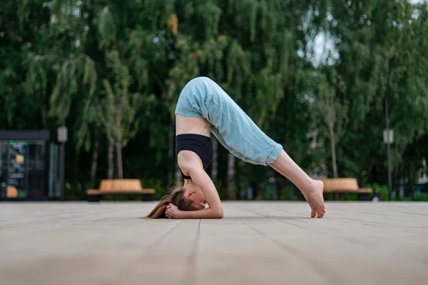 Dívka cvičí jógu a meditaci ve městě. — Stock fotografie