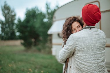 Romantik çift karavanın yanında birlikte vakit geçiriyorlar. Karavanla birlikte seyahat ediyoruz..