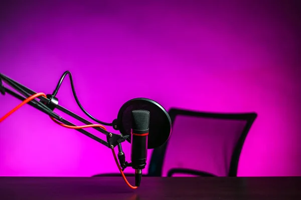 Un micrófono en la mesa y un sillón rosa retroiluminado. Video blogger lugar de trabajo —  Fotos de Stock