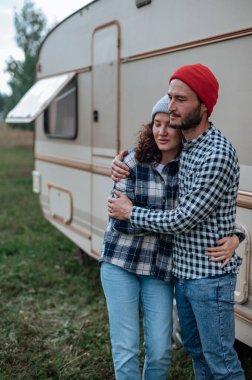 Romantik çift karavanın yanında birlikte vakit geçiriyorlar. Karavanla birlikte seyahat ediyoruz..