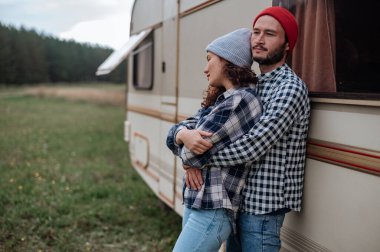 Romantik çift karavanın yanında birlikte vakit geçiriyorlar. Karavanla birlikte seyahat ediyoruz..