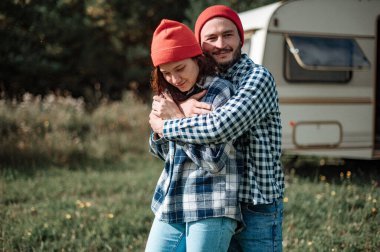 Romantik çift karavanın yanında birlikte vakit geçiriyorlar. Karavanla birlikte seyahat ediyoruz..