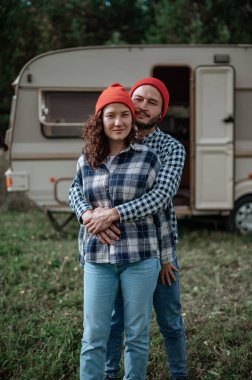 Romantik çift karavanın yanında birlikte vakit geçiriyorlar. Karavanla birlikte seyahat ediyoruz..