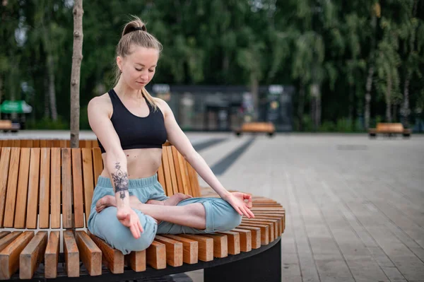 Dívka cvičí jógu a meditaci ve městě. — Stock fotografie