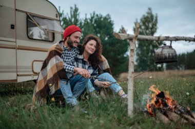 Romantik çift karavanın yanında birlikte vakit geçiriyorlar. Karavanla birlikte seyahat ediyoruz..