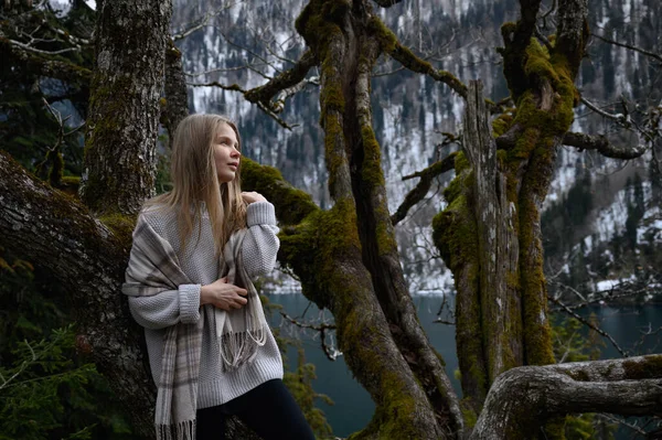 Girl sits on a tree and meditates near lake Ritsa in Abkhazia — Stock Photo, Image