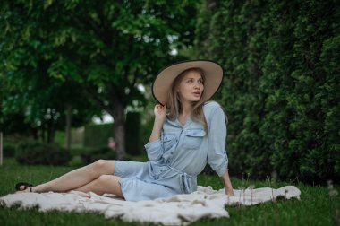Parkta piknikte şapkalı romantik kız.