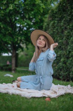 Parkta piknikte şapkalı romantik kız.