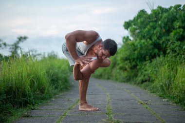 Erkek, dışarıda yoga ve meditasyon pratiği yapıyor.