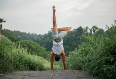 Erkek, dışarıda yoga ve meditasyon pratiği yapıyor.