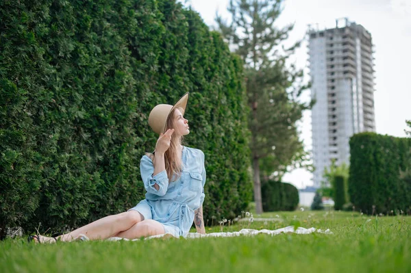 The girl dreams of a new apartment. Romantic girl with hat on picnic in park. — Stock Photo, Image