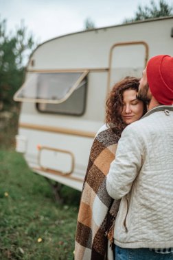 Romantik çift karavanın yanında birlikte vakit geçiriyorlar. Karavanla birlikte seyahat ediyoruz..