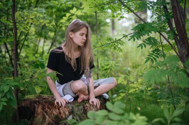 Meditasyon ve doğayla etkileşim pratiği. Yeşil ormandaki kız