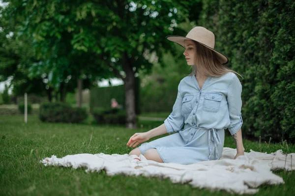 The girl dreams of a new apartment. Romantic girl with hat on picnic in park. — Stock Photo, Image