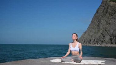 Yoga antrenmanı ve dışarıda meditasyon. Rıhtımdaki kız denizin arka planında