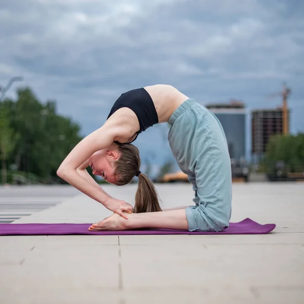 Dívka cvičí jógu a meditaci ve městě. — Stock fotografie