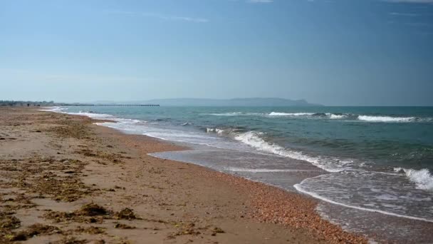Linia brzegowa przeciwko błękitnemu morzu z żółtym piaskiem. — Wideo stockowe
