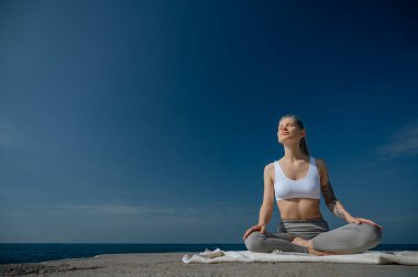 Yoga ve meditasyon doğada var. Karadeniz yakınlarında çalışan bir kadın..