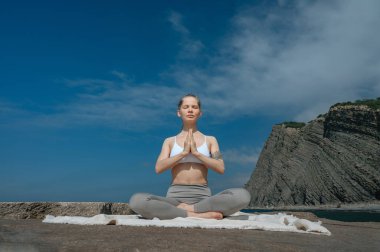 Yoga ve meditasyon doğada var. Karadeniz yakınlarında çalışan bir kadın..