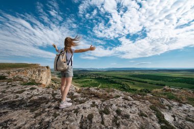 Sırt çantasıyla dağda gezen bir kız..
