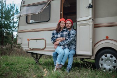 Romantik çift karavanın yanında birlikte vakit geçiriyorlar. Karavanla birlikte seyahat ediyoruz..