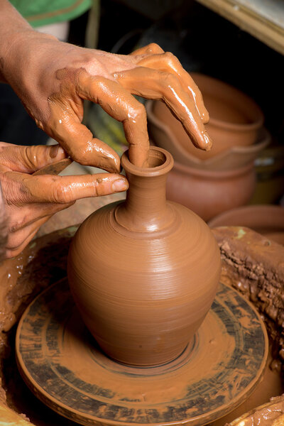 руки горшечника, создающего глиняную банку