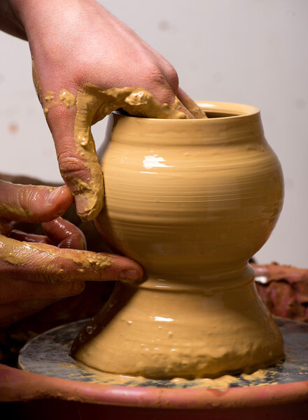 hands of a potter, creating an earthen jar
