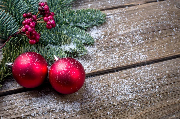 Sfondo di Natale con un ornamento rosso, bacche e abete in neve — Foto Stock