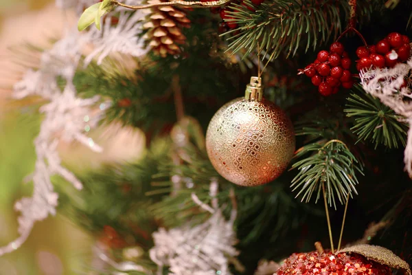 Kerstmis achtergrond met een gouden ornament, bessen en Spar in sneeuw — Stockfoto