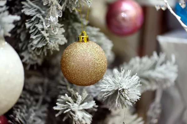 Fondo de Navidad con un adorno de oro y abeto en la nieve —  Fotos de Stock