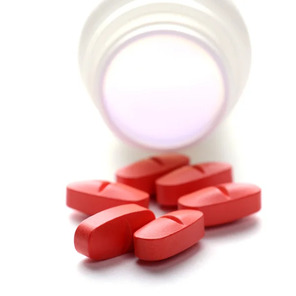 Pílulas em frasco pílula no fundo branco — Fotografia de Stock