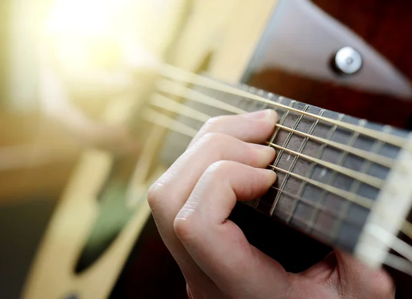 Die Hände eines Mannes, der eine akustische Gitarre spielt, aus nächster Nähe — Stockfoto