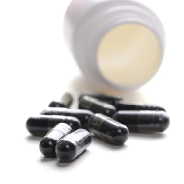 Pilules en bouteille de pilule sur fond blanc — Photo