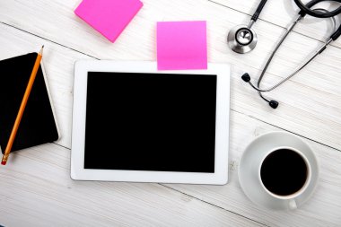 Tablet bilgisayarınızla stetoskop ve ahşap backg diğer araçları