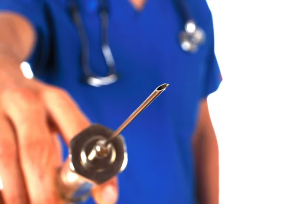 Doctor with stethoscope shows a big syringe isolated on white — Stock Photo, Image