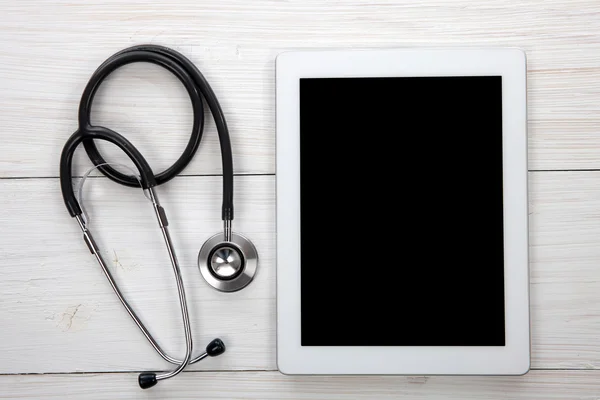 Tablet Computer con stetoscopio blu su sfondo di legno — Foto Stock