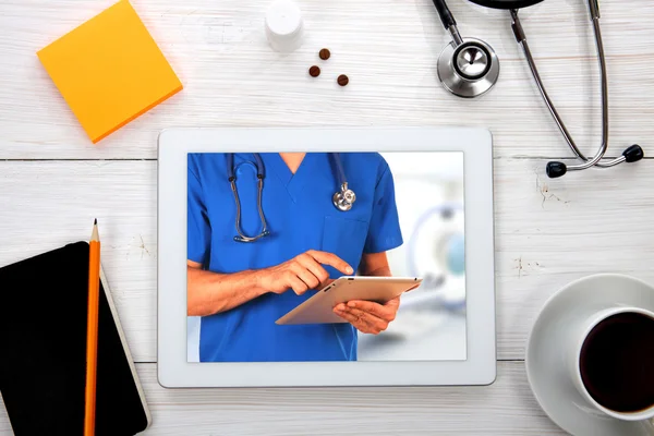 Tablet computer with stethoscope and other tools on wooden backg — Stock Photo, Image