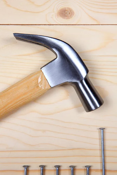 Hammer und Nägel auf Holzgrund — Stockfoto
