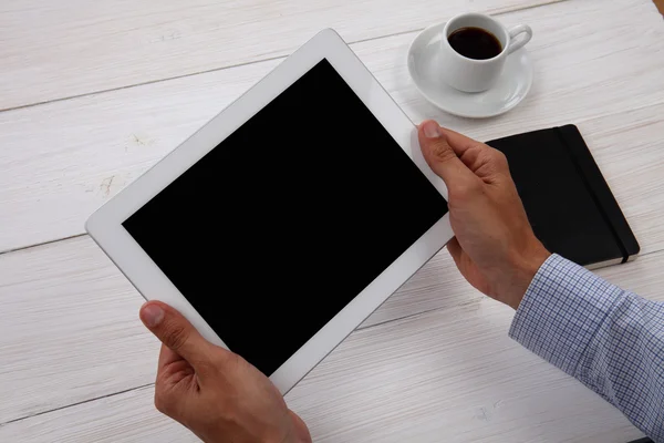 Руки, що тримають порожній цифровий планшет, блокнот і чашку кави — стокове фото