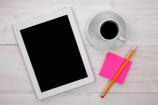 Mãos segurando tablet digital em branco, bloco de notas e xícara de café em Imagens Royalty-Free