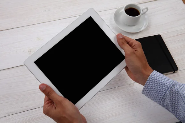 Mani che tengono in bianco tablet digitale, blocco note e una tazza di caffè su Foto Stock