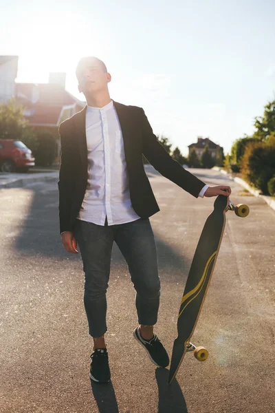 Imagem de um homem com longboard indo na estrada — Fotografia de Stock