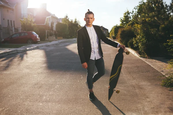 Immagine di un uomo con longboard che va su strada — Foto Stock