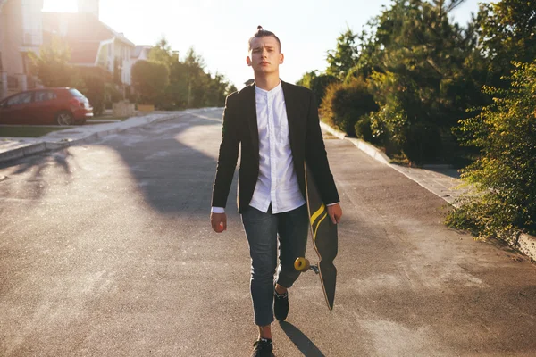 Image of a man with longboard going on road — Stock Photo, Image