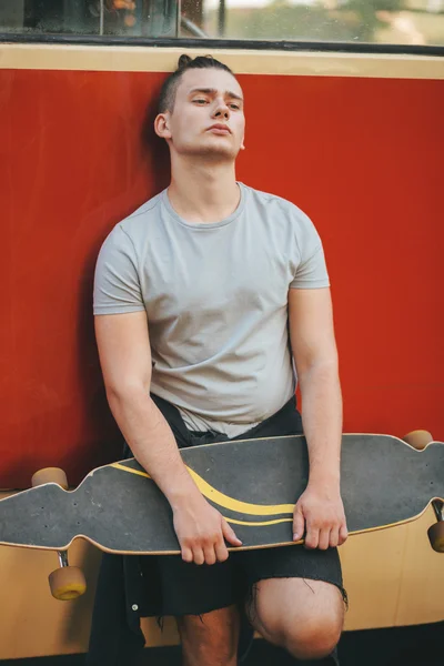 Image of a man with longboard going on road — Stock Photo, Image