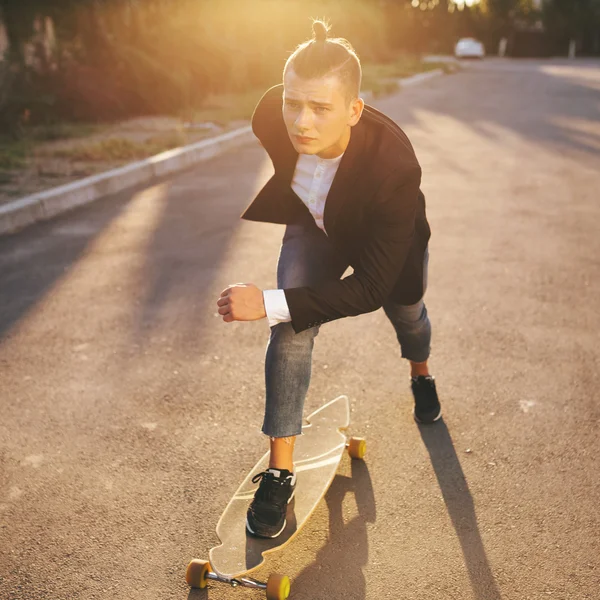 Image of a man with longboard going on road — Stock Photo, Image