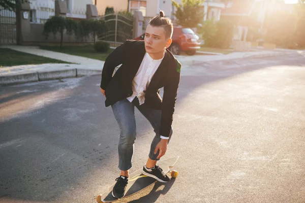 Immagine di un uomo con longboard che va su strada — Foto Stock